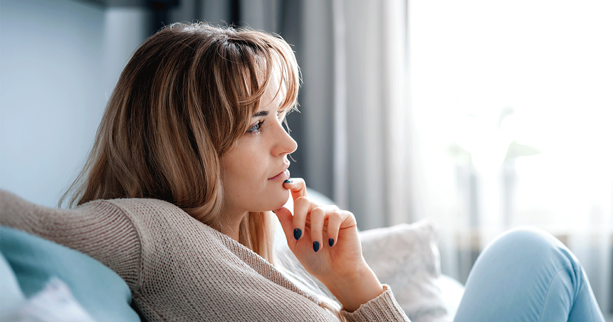 Contemplative pregnant woman exploring her options without health insurance.